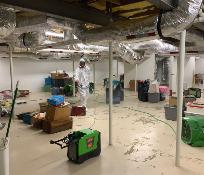 SERVPRO cleaning up water damage on floor in commercial building basement.